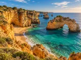 Illustration of Golden sea cliffs, arch and turquoise cove on the central Algarve coast