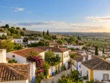 Illustration of White houses and terracotta rooftops in Óbidos; representative medieval town fabric, no exact castle or church claimed.