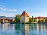 Illustration of Maribor Water Tower / Vodni stolp beside the Drava on Lent, viewed obliquely from a nearby riverside viewpoint